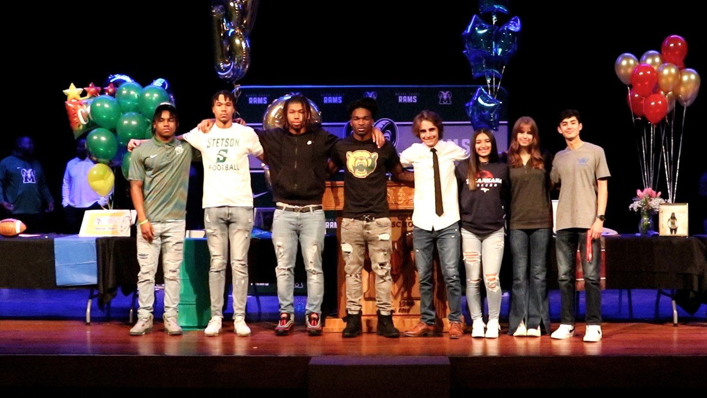 Mayde Creek student-athletes celebrate after signing a national letter of inter to play a sport in college.